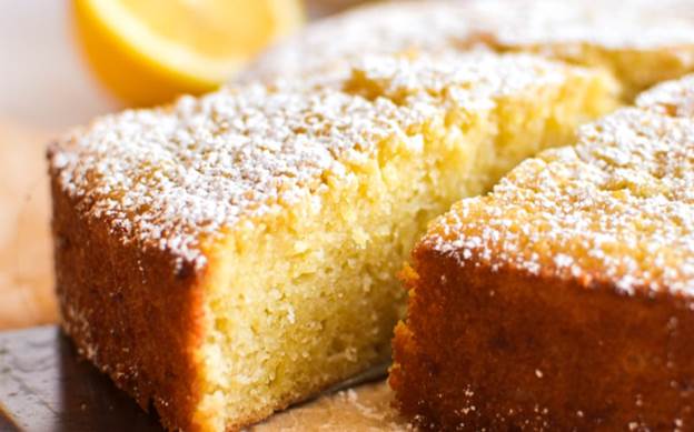 taking a slice of lemon olive oil cake, topped with sugar