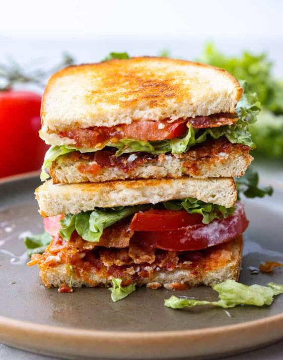 A BLT sandwich cut in half and stacked on top of each other.